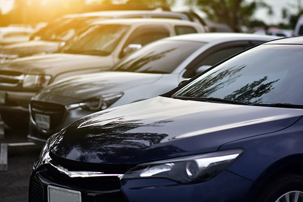 Row of cars in parking lot that have auto insurance